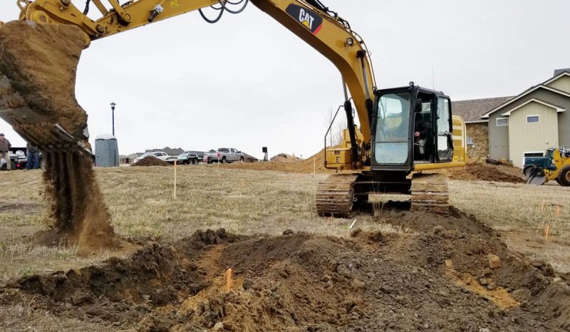 finding an architect or designer: backhoe breaking ground on a custom home